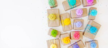 Renkli kurdeleler ve ponpon ile renkli hediye kutuları. Beyaz backg