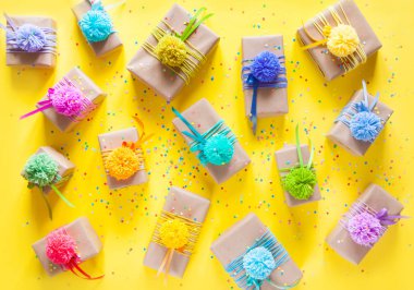 Renkli kurdeleler ve ponpon ile renkli hediye kutuları. Sarı geri