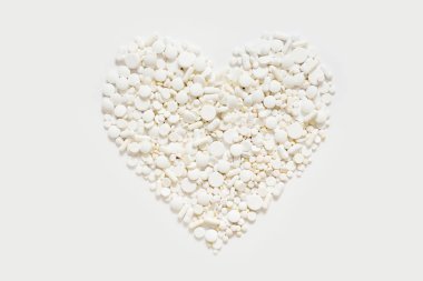 Beyaz arka plan üzerinde beyaz hap şekilden kalp.