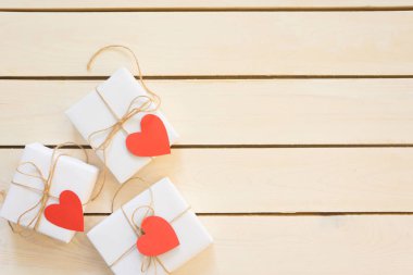 Hafif ahşap arka plan üzerinde beyaz hediye kutuları. Valent için hediyeler
