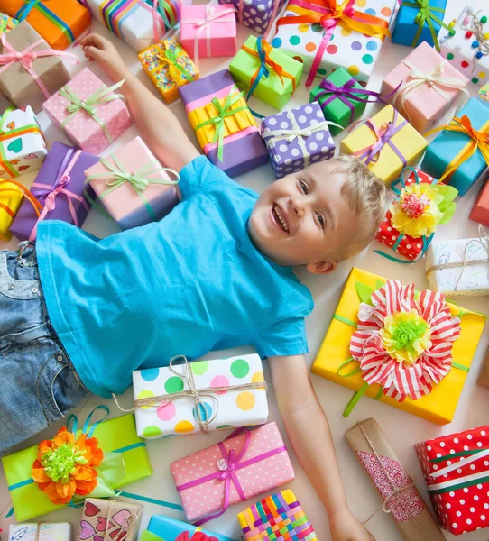 子供にはプレゼントが散らばっています。少年が床にあると — ストック写真