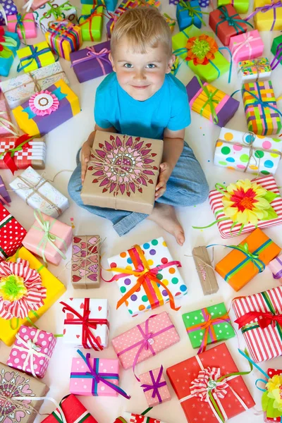 아이 아름 다운 선물을 들고 있다. 아이 바닥에 앉아 — 스톡 사진