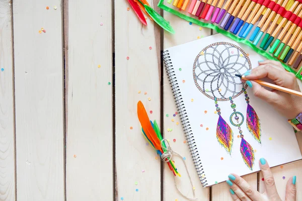 Een meisje tekent een dream catcher met gekleurde markeringen. — Stockfoto