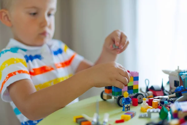屋内のカラフルなプラスチック製のブロックがたくさん遊んで金髪の子供の小さな男の子 レゴのブロックが並べられます 古典的なレゴの保管 — ストック写真