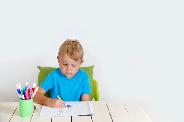Ein fünfjähriger Junge zeichnet mit Buntstiften Häuser. Zeichnung h — Stockfoto