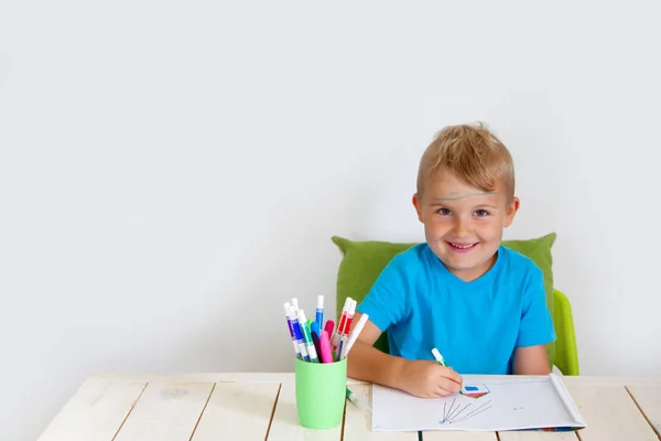 Ein fünfjähriger Junge zeichnet mit Buntstiften Häuser. Zeichnung h — Stockfoto