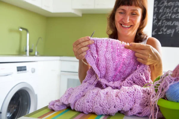 Una mujer teje con agujas de punto una sábana lila hecha de grueso — Foto de Stock