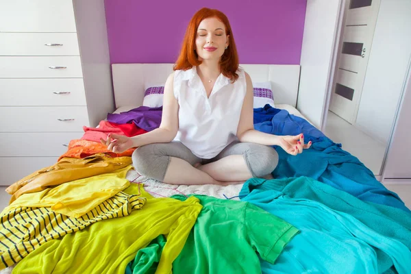 A circle of clothes of all colors of the rainbow. Different clothes lie on the bed all around.