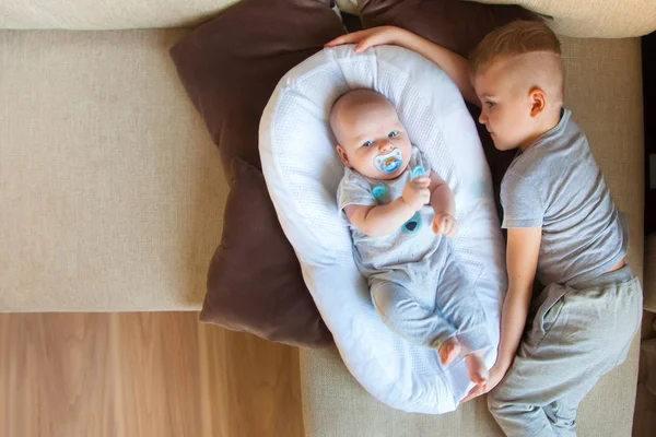 Older Brother Looks Plays His Younger Brother Neutral Tones — Stock Photo, Image