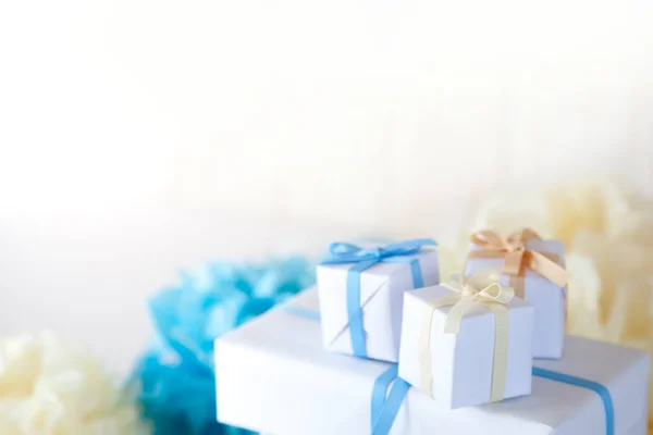 Caja de regalos blanca con cintas azules, amarillas y beige en el whi —  Fotos de Stock