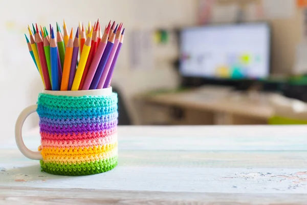 Colored pencils in a pencil case on workspace and workshop background