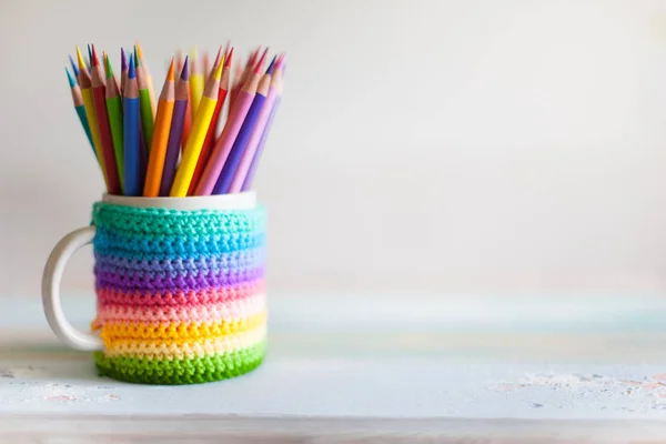 Colored pencils in a pencil case on workspace and workshop background