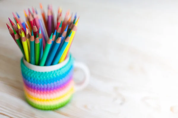 Colored pencils in a pencil case on workspace and workshop background