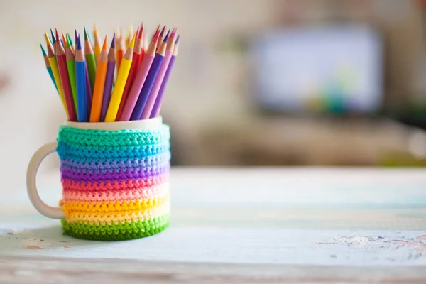 Colored pencils in a pencil case on workspace and workshop background