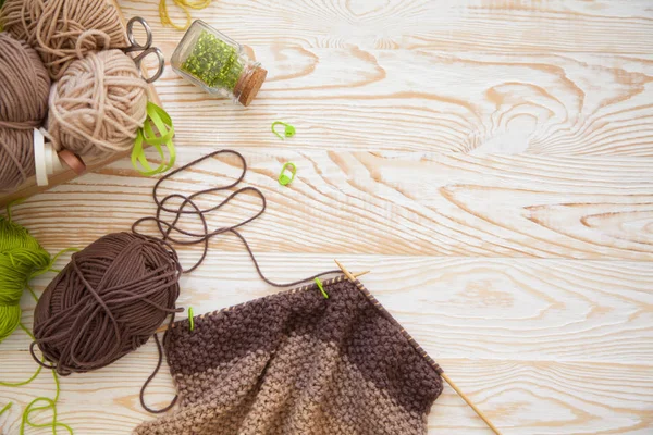 A woman knits a white and broun knitted fabric of woolen yarn. K — Stock Photo, Image