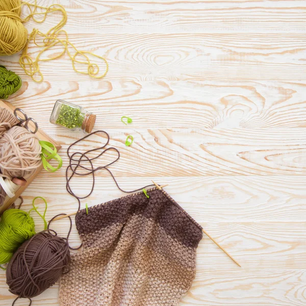 Una donna lavora a maglia un tessuto bianco e broun di filato di lana. K — Foto Stock