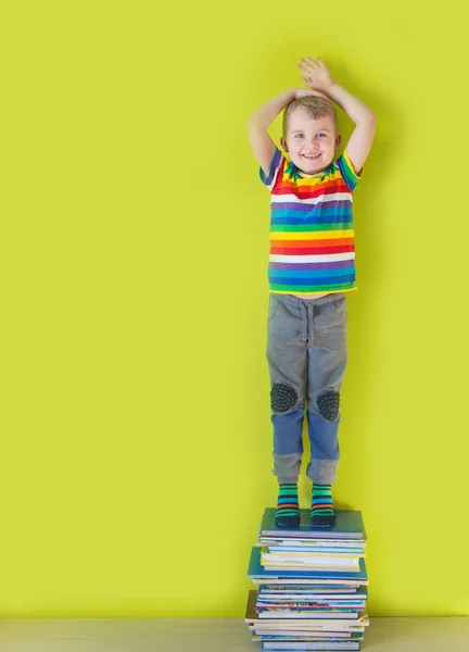 Un gioioso bambino sorridente è in piedi su una pila di bo per bambini — Foto Stock