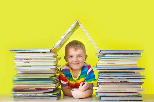 Il bambino siede all'interno di una casa fatta di libri per bambini. Ba verde — Foto Stock