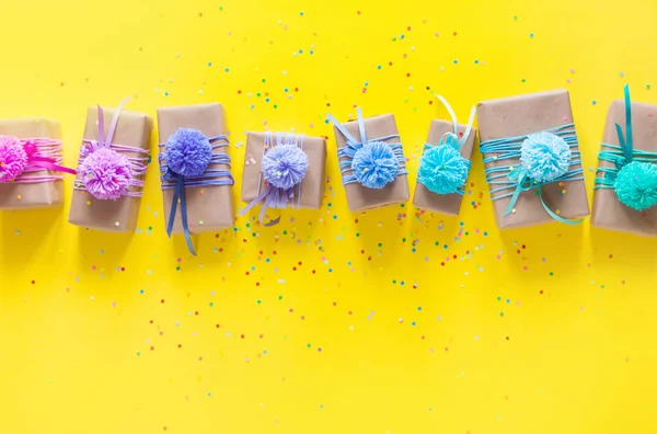 Gekleurde geschenkdozen met kleurrijke linten en pompon. Geel is terug — Stockfoto