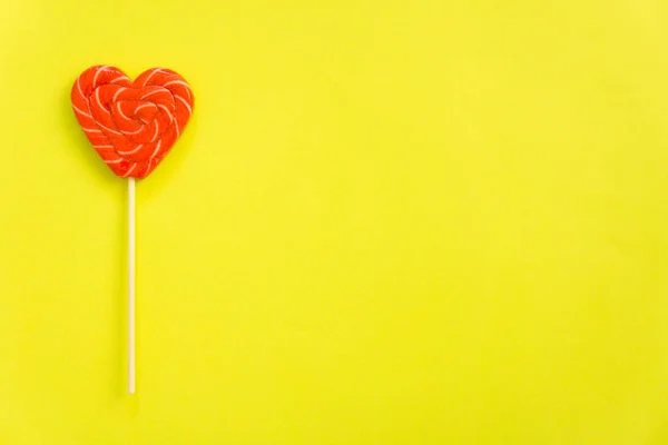 Red lollipop. Candy in the form of heart.