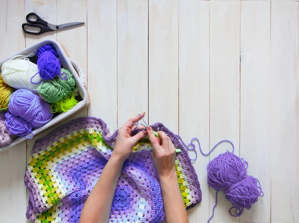 Mani femminili che lavorano a maglia con lana a colori, vista dall'alto — Foto Stock