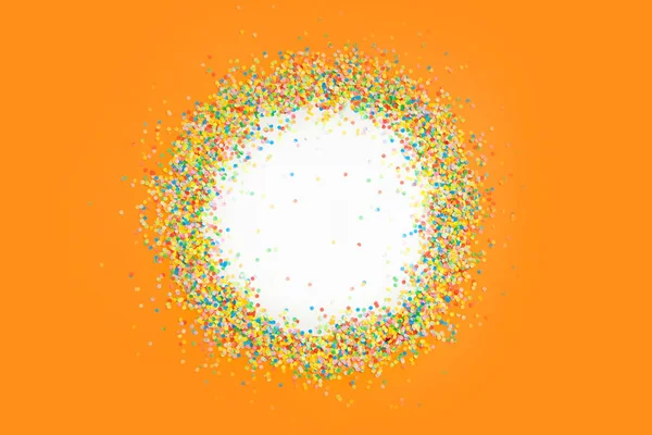 Marco redondo hecho de confeti de color. Fondo naranja. Festivo — Foto de Stock