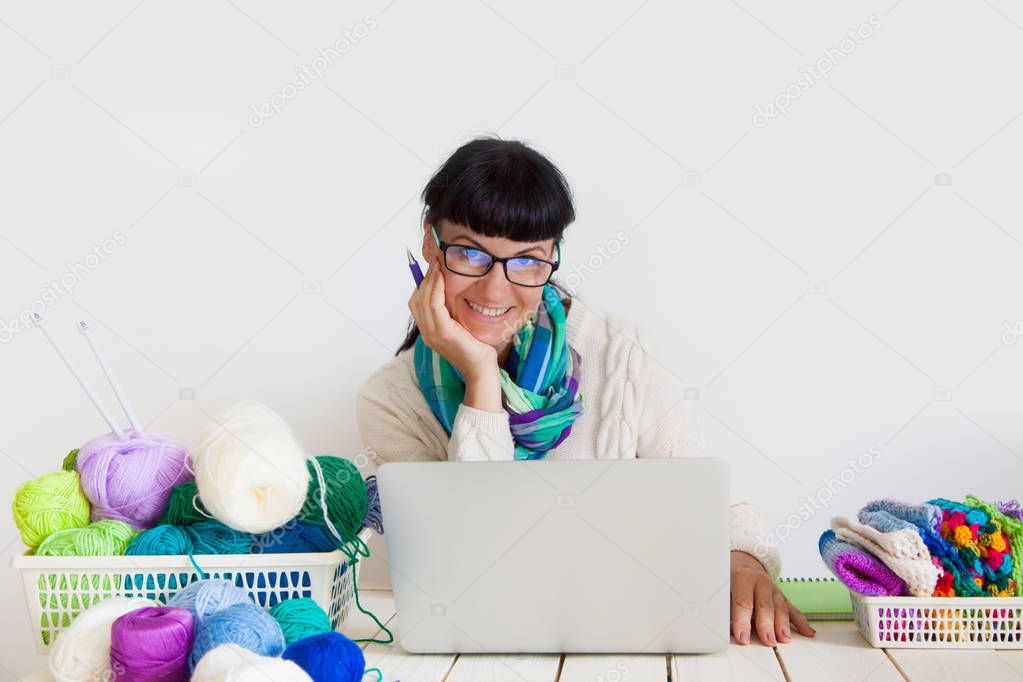 Young woman in her workshop. Knitting and crocheting. Hairs of yarn in a basket. White background.
