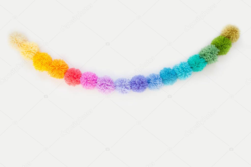 Pompons of colored yarn. White background. Bright colours.