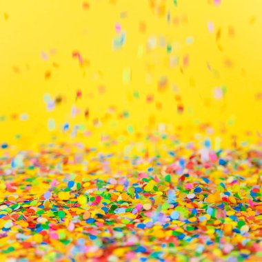 Renkli konfeti sarı arka plan üzerinde uçan