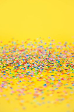 Renkli konfeti sarı arka plan üzerinde uçan