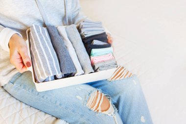 Bir kız bir sepet çeşitli ve temiz çorap ve tutar. Beyaz backg