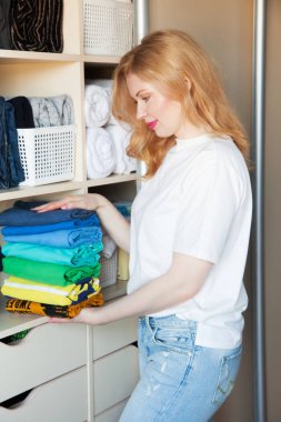 Kadın giyim dikey bir dolap raf üzerinde pas geçiyor. Japon sto