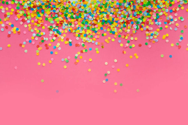 Round frame made of colored confetti. Pink background. Festive c