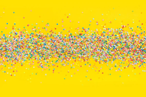 Marco hecho de confeti de color. Fondo amarillo — Foto de Stock