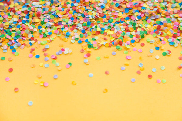 Рамка из цветных конфетти. Желтый фон
