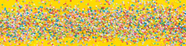 Fémkeret színes konfetti. Sárga háttérrel — Stock Fotó
