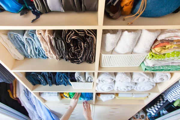 Женщина складывает одежду вертикально на полке шкафа. Японский язык — стоковое фото