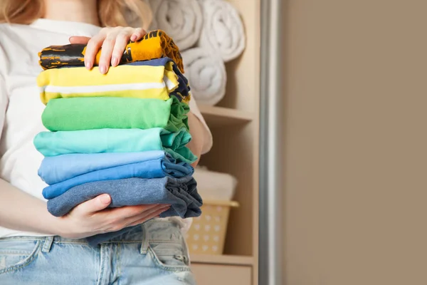 Mulher dobra roupas verticalmente em uma prateleira de guarda-roupa. Japonês sto — Fotografia de Stock