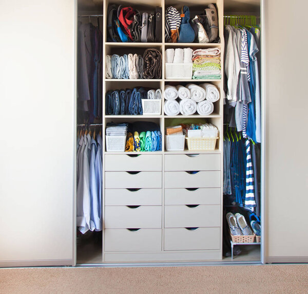 Одежда лежит в ящике в шкафу. Футболки для женщин
