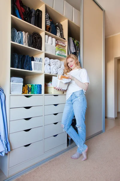 La chica pone las cosas en orden en el armario. Vertical japonés — Foto de Stock