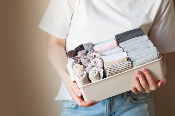 La chica sostiene una cesta, una caja con una cosa plegada verticalmente — Foto de Stock