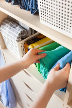 Kadın giyim dikey bir dolap raf üzerinde pas geçiyor. Japon sto