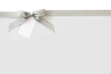 Beyaz arka plan üzerinde bir hediye olarak bir yay ile Gümüş kurdele