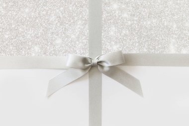 Beyaz ve parlak bir backgrou bir hediye olarak bir yay ile Gümüş kurdele