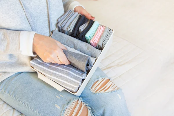 Bir kız bir sepet çeşitli ve temiz çorap ve tutar. Beyaz backg