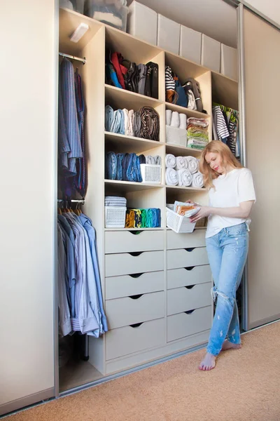 La chica pone las cosas en orden en el armario. Vertical japonés — Foto de Stock