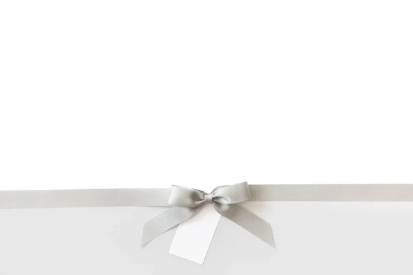 Beyaz ve parlak bir backgrou bir hediye olarak bir yay ile Gümüş kurdele — Stok fotoğraf