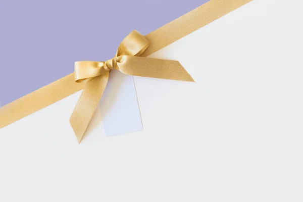 Beyaz ve lavanta backgro bir hediye olarak bir yay ile Altın kurdele — Stok fotoğraf