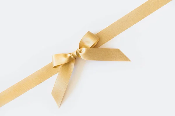 Gold ribbon with a bow as a gift on a white background — Stock Photo, Image