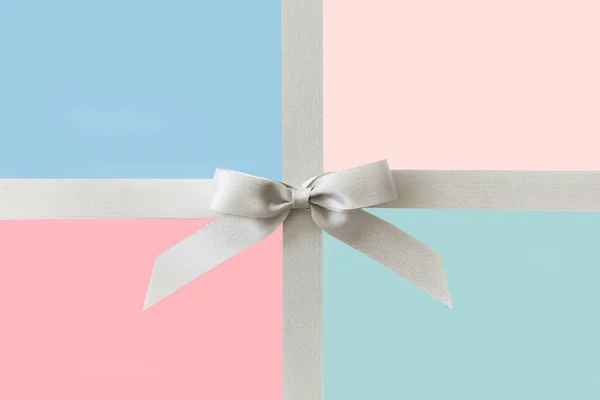 Pastel renkler arka planda hediye olarak bir yay ile Gümüş kurdele — Stok fotoğraf